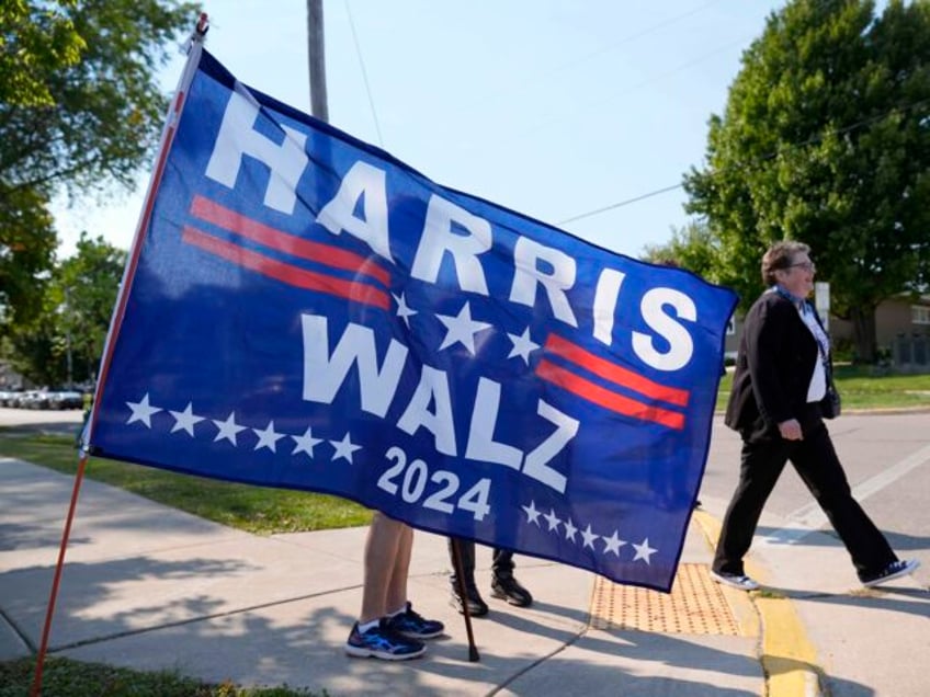 A supporter walks past a flag at a vendor stand before the arrival of Democratic president