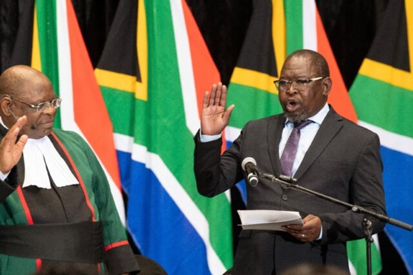 South African Chief Justice Raymond Zondo (L) swears in Enoch Godongwana as finance minist