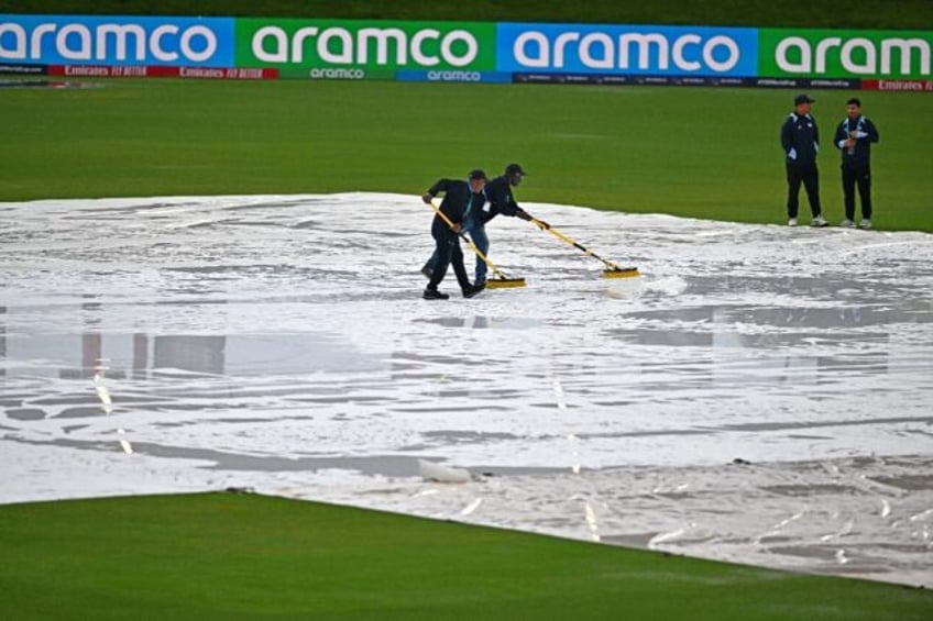 Match officials wipe water from the pitch but the ICC men's Twenty20 World Cup 2024 group