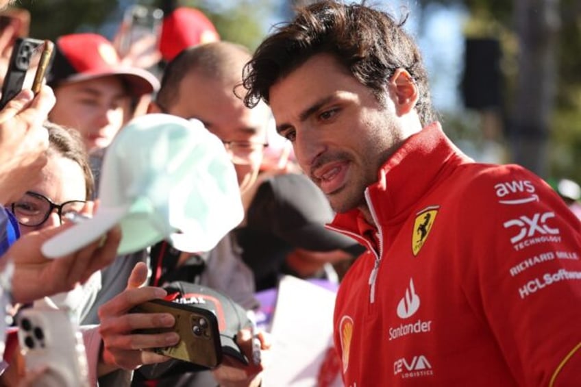 Ferrari's Carlos Sainz poses for photos with fans at the Albert Park Circuit ahead of the