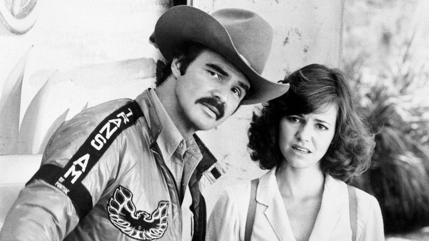 Sally Field and Burt Reynolds standing together and appearing perplexed