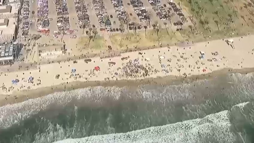 rescuers digging out teen at beach