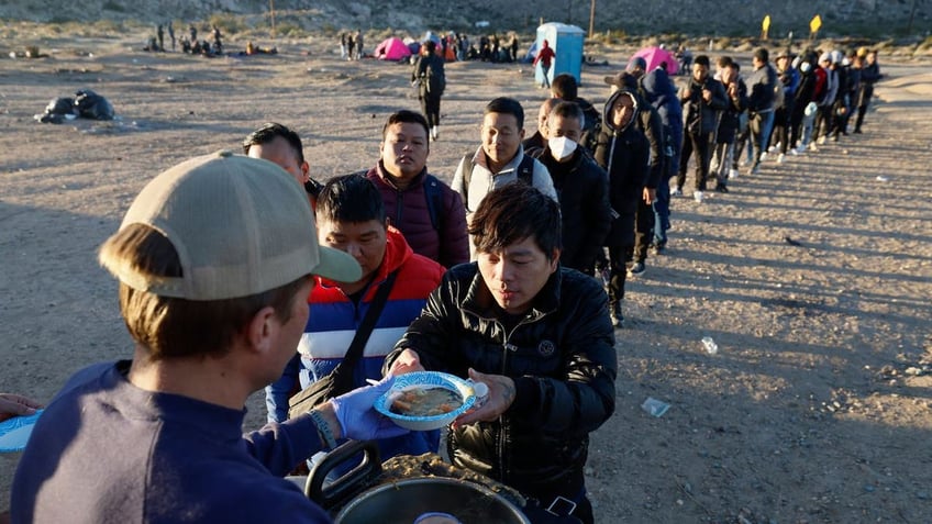 Migrants warm a truck in Jacumba, California delivering hot food that was prepared, cooked and delivered by a small group of local volunteers.