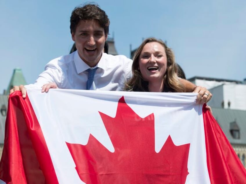 Canadian athlete Rosie MacLennan and Prime Minister Justin Trudeau hold up a Canadian flag