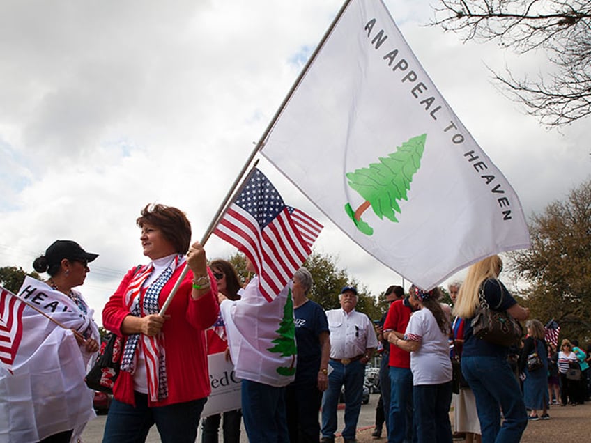 Cynthia Guzowski (far left) and Beth Walker (center with flag) hold The Tree Flag (or Appeal to Heaven Flag) which was one of the flags used during the American Revolution. They are standing in line to attend a Ted Cruz rally at the Shrine auditorium in San Antonio. (Photo by Lucian Perkins /for The Washington Post via Getty Images)