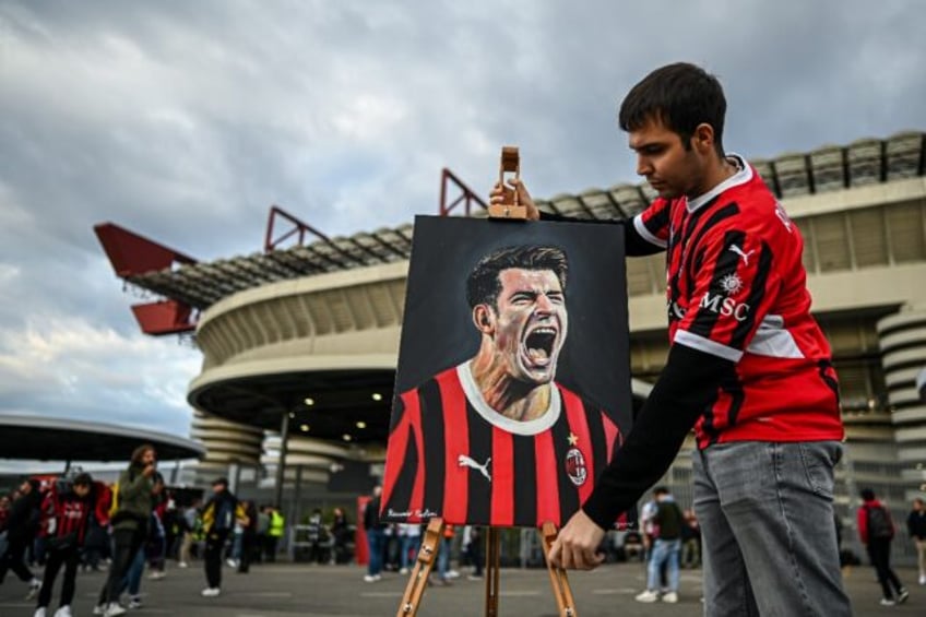 AC Milan supporter Riccardo Paolini displays his painting of striker Alvaro Morata outsi