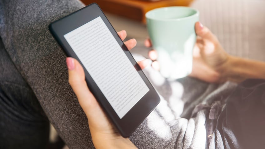 A person reading on a Kindle