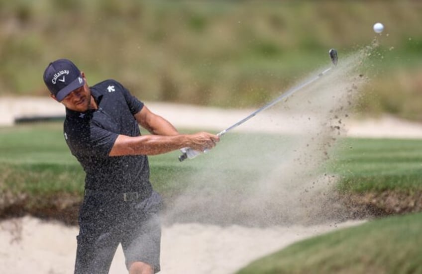 World number two Xander Schauffele of the United States blasts out of a bunker on the thir
