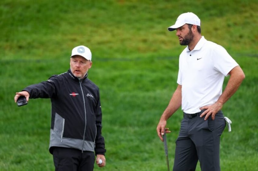 Top-ranked Scottie Scheffler, right, works with putting coach Phil Kenyon, left, during a