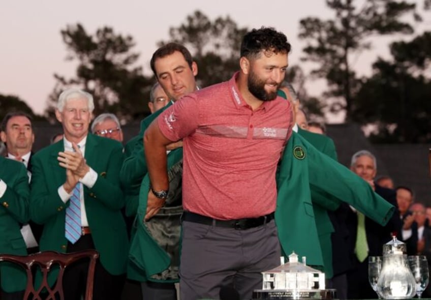 Spain's Jon Rahm is helped into the Masters winner's green jacket by 2022 Masters winner S