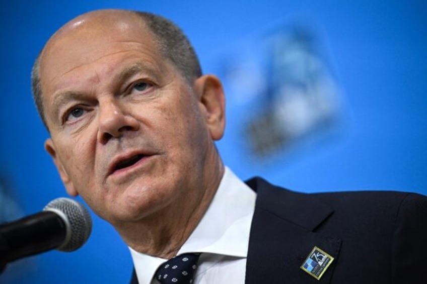 German Chancellor Olaf Scholz speaks to reporters at the NATO 75th anniversary summit in W