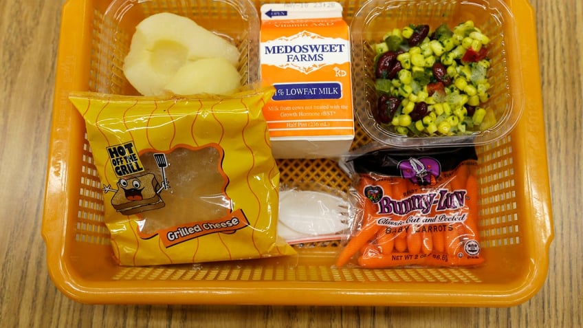 A school lunch featuring a grilled cheese sandwich on whole grain bread is served with a southwestern-style corn salad, fresh carrots and either canned pears or apple sauce Monday, May 5, 2014, at Mirror Lake Elementary School in Federal Way, Wash., south of Seattle. On this day, students could choose between this lunch or a green salad entree option featuring low-sodium chicken, a whole-grain roll, fresh red peppers, and cilantro dressing. (AP Photo/Ted S. Warren)