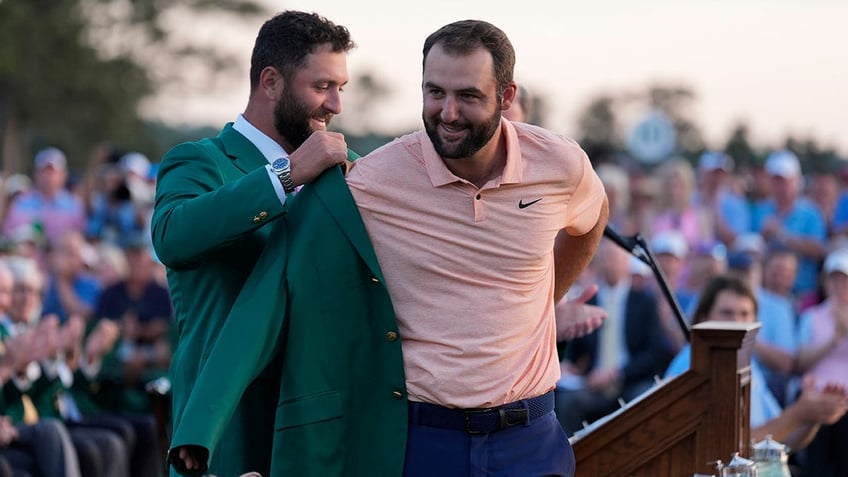 Jon Rahm puts the jacket on Scottie Scheffler