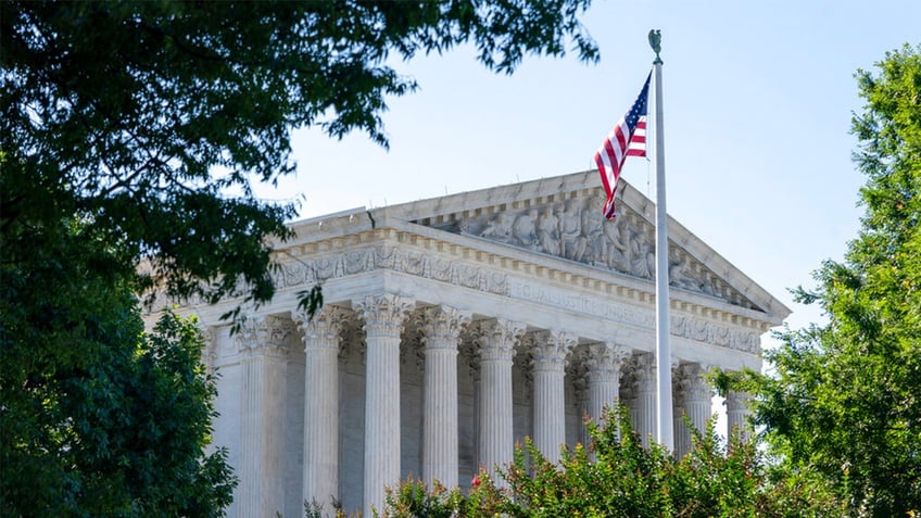 US Supreme Court building with US flag in front