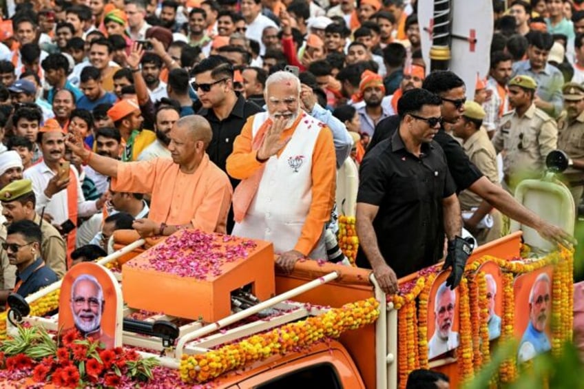 India's Prime Minister Narendra Modi waves to the crowd during his roadshow in Varanasi on