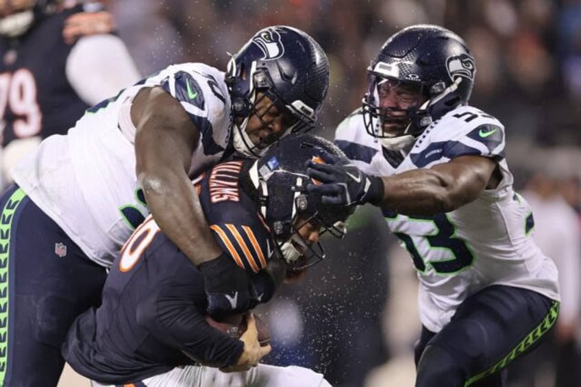 Seattle's Jarran Reed, left, sacks Chicago quarterback Caleb Williams in a defense-dominat