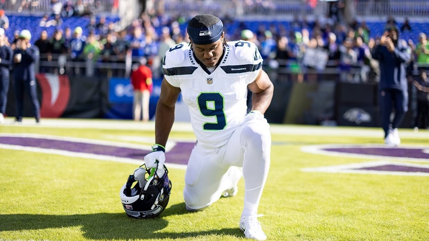 Kenneth Walker III kneels in end zone