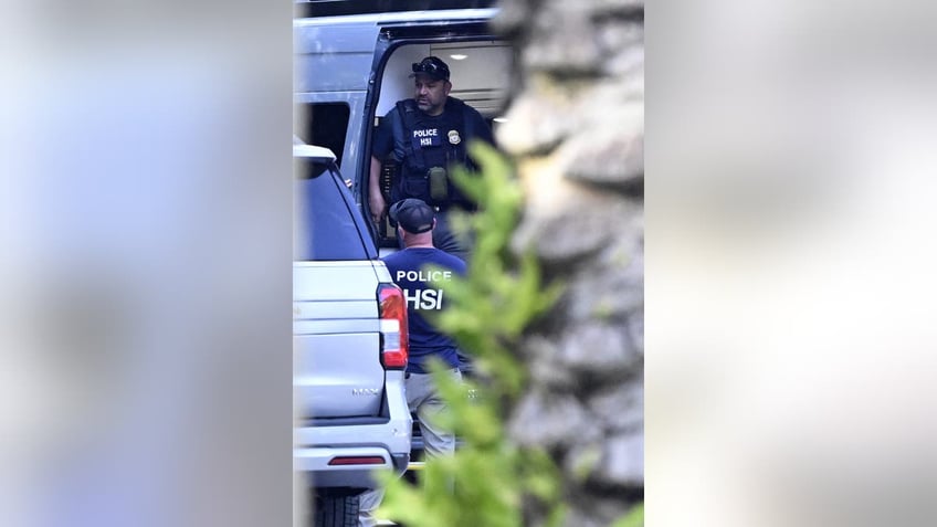 Police and Homeland Security officers are seen at the waterfront mansion of Sean Combs