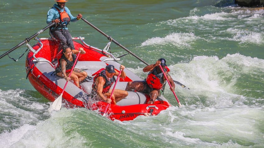 Sean "Diddy" Combs white water rafting in a red raft