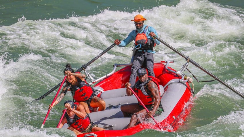 Sean "Diddy" Combs plunging into the water while white water rafting