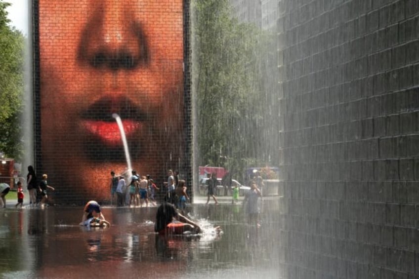 People cool off at Crown Fountain in Chicago's Millennium Park, as temperatures soar and o