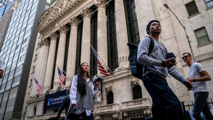 Pedestrians pass the New York Stock Exchange