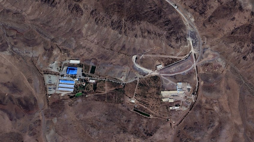 Satellite imagery shows the Shahid Soltani Garrison, outside of Eshtehard City, Iran, including large storage warehouses (left), a set of smaller buildings (right) and an underground tunnel with two openings (center).