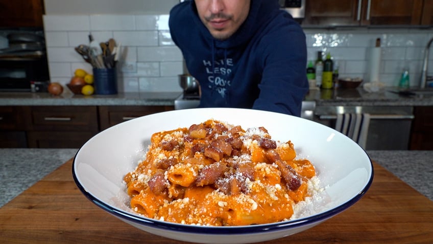 Stephen holding a plate of pasta.