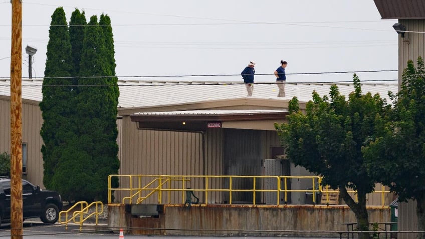 FBI investigators on the roof of the building where the would-be assassin shot at former president Donald Trump