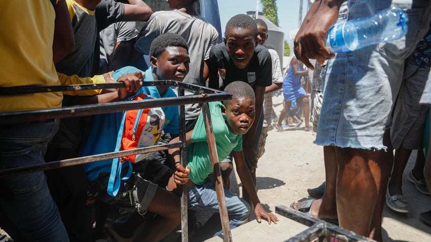 Children take cover from gunshots in Haiti