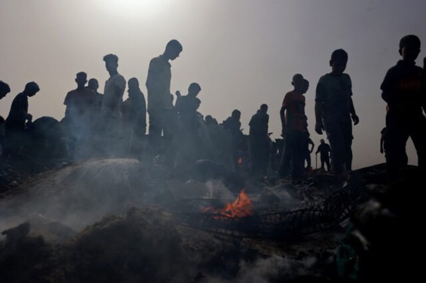 Palestinians gather at the site of a deadly Israeli strike at a camp for internally displa