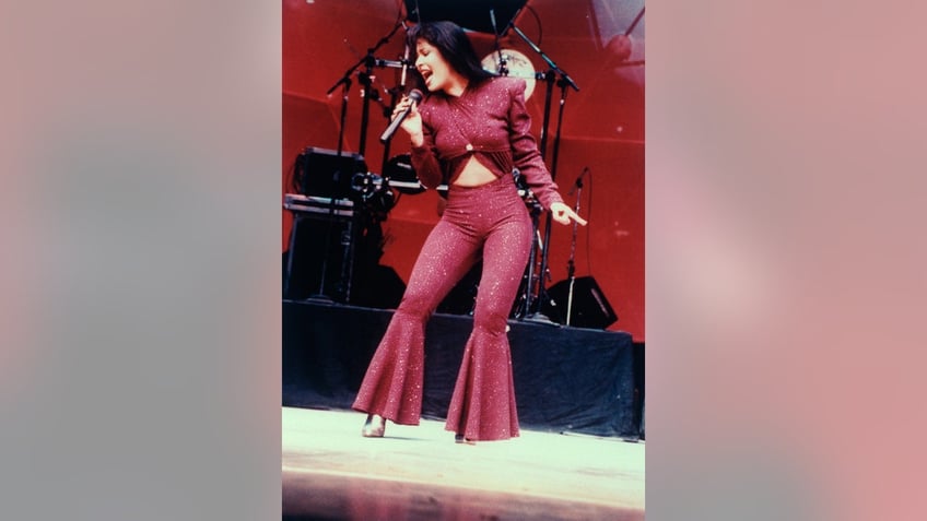 Selena performing in a purple jumpsuit