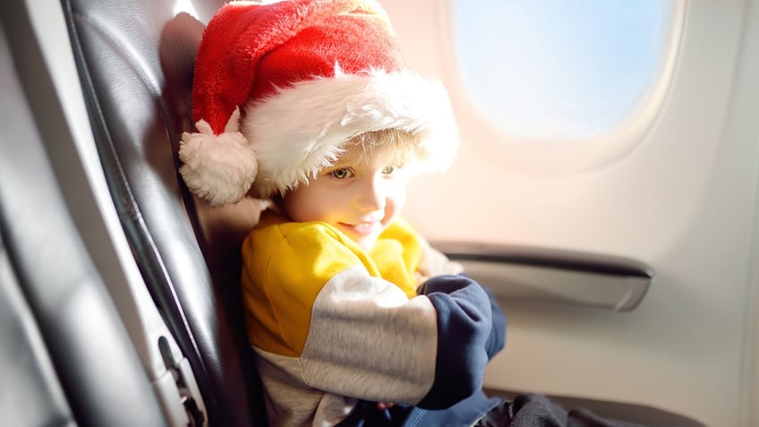 young boy in santa hat on plane