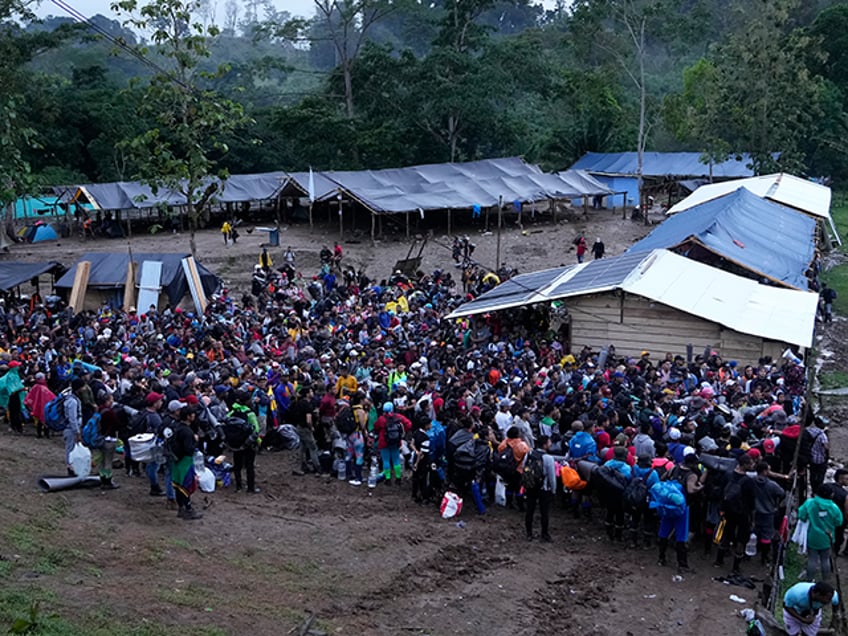 A group of migrants, mostly Venezuelans, prepare to start crossing the Darien Gap from Colombia into Panama hoping to reach the U.S., Saturday, Oct. 15, 2022. (AP Photo/Fernando Vergara)