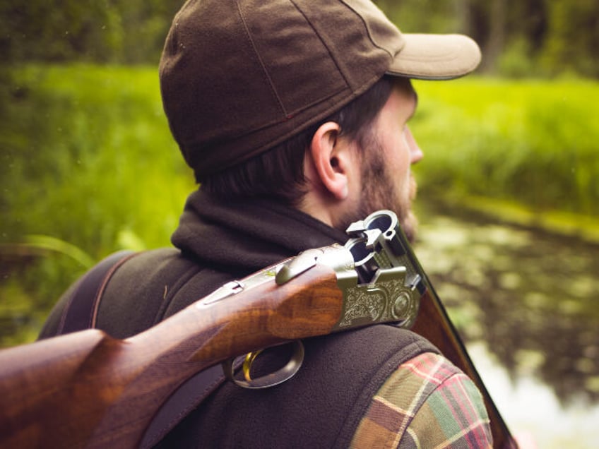 Hunter With Open Shotgun On Shoulder