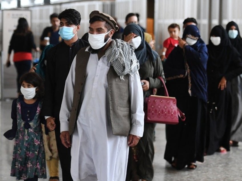 Afghan refugees arrive at Dulles International Airport on August 27, 2021 in Dulles, Virginia, after being evacuated from Kabul following the Taliban takeover of Afghanistan. - The Pentagon said on Friday the ongoing evacuation from Afghanistan faces more threats of attack a day after a suicide bomber and possible associated gunmen killed scores at a Kabul airport gate. (Photo by Olivier DOULIERY / AFP) (Photo by OLIVIER DOULIERY/AFP via Getty Images)