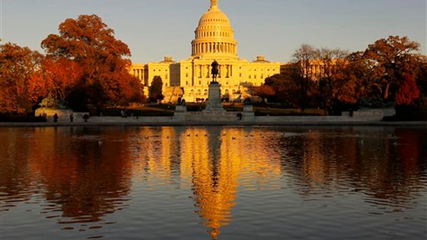 The US Capitol is bathed in the setting sun and seen in the reflecting pool on Capitol Hill in Washington, Friday, Nov. 12, 2010. Congress returns next week for a post-election lame duck session. (AP Photo/Alex Brandon)