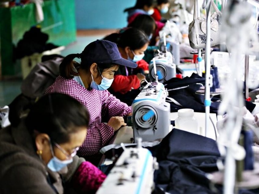 CHONGQING, CHINA - OCTOBER 26, 2021 - Relocated households sew clothes at a garment factor