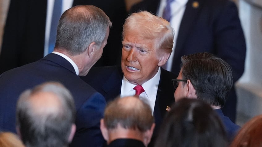 President Donald Trump talks to Senate Majority Leader John Thune, R-S.D., left, and House Speaker Mike Johnson, R-La., after speaking at the National Prayer Breakfast in Washington on Feb. 6, 2025.