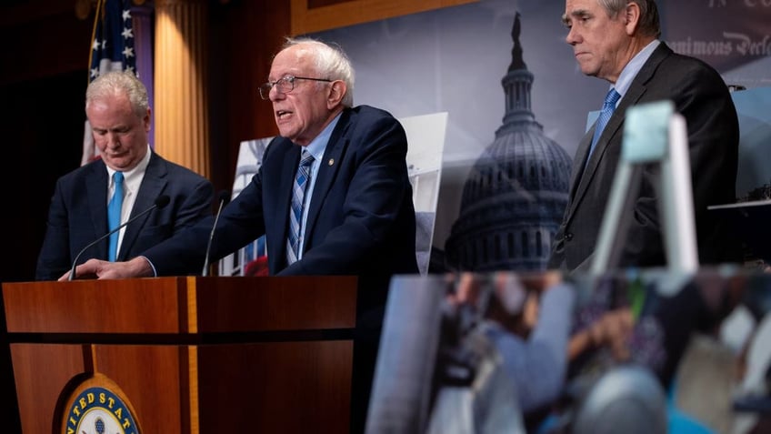 Sanders at podium with other senators