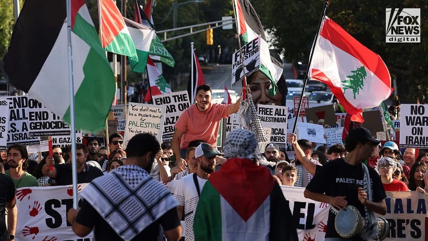 Pro-Hamas protestors wave flags an carry placards as they march in Raleigh, NC