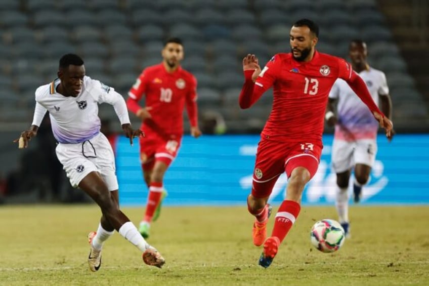 Nader Ghandri (R) of Tunisia fails to block a shot by Bethuel Muzeu of Namibia in a 2026 W