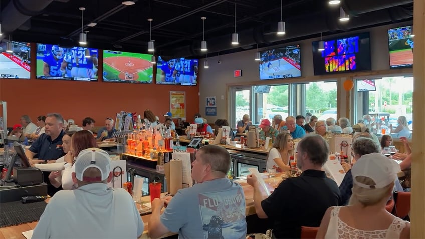 A packed bar is shown at a Hooters in The Villages, Florida.