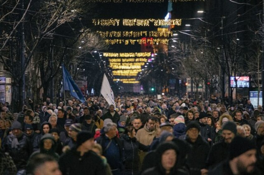 Opposition supporters march in Belgrade Tuesday to protest against last month's elections