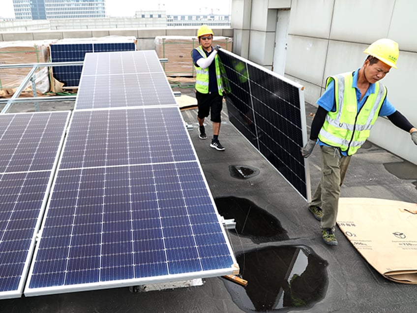 Workers install solar panels on the roof of factory buildings at a small and medium-sized enterprises park on July 5, 2022 in Lianyungang, Jiangsu Province of China. (Photo by VCG/VCG via Getty Images)