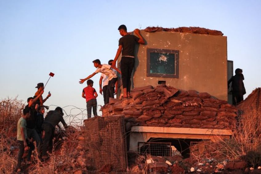 Syrian demonstrators vandalise a Turkish army observation point during a protest in Ibbin