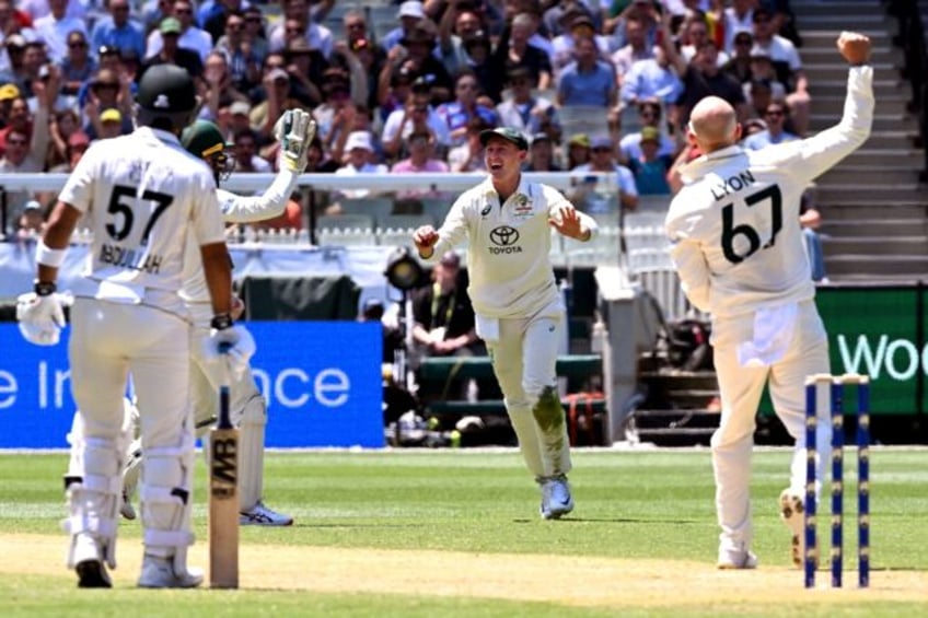 Australia's fieldsman Marnus Labuschagne (C) takes a catch to dismiss Pakistan's batsman Imam-ul-Haq