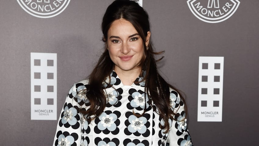 Shailene Woodley in a patterned jacket with flowers soft smiles on the carpet