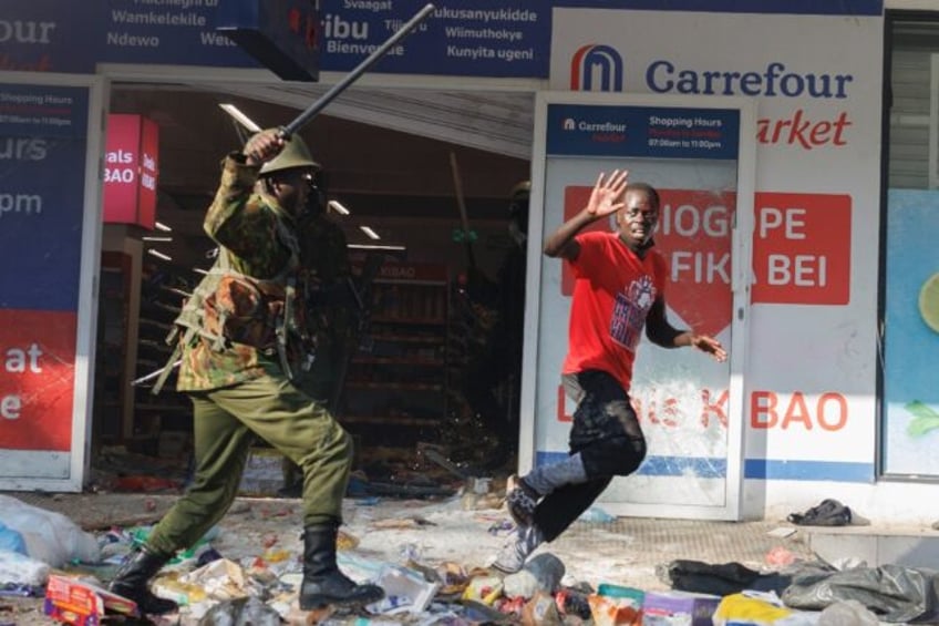 A protester tries to escape from a policeman during a demonstration in Nairobi, on June 25
