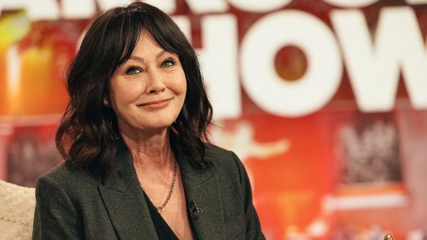 Shannen Doherty smiles in a black blazer